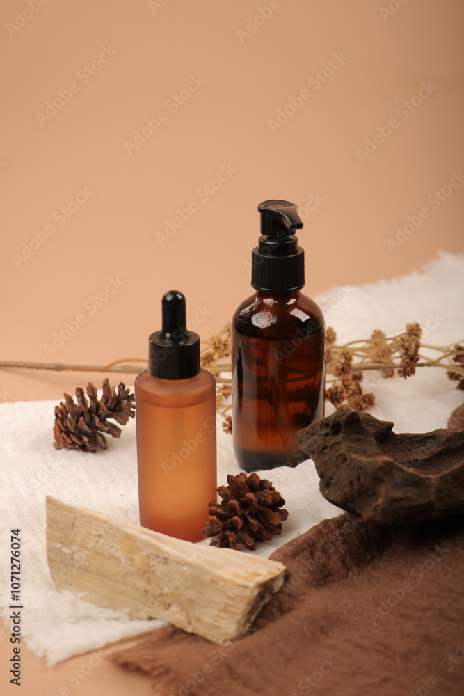 Amber Glass Bottles with Rustic Pinecones and Wooden Decor on Textured Fabric Amber Glass Bottles with Rustic Pinecones and Wooden Decor on Textured Fabric
