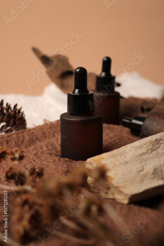 Frosted Amber Dropper Bottles with Rustic Decor and Dried Flowers on Textured Fabric