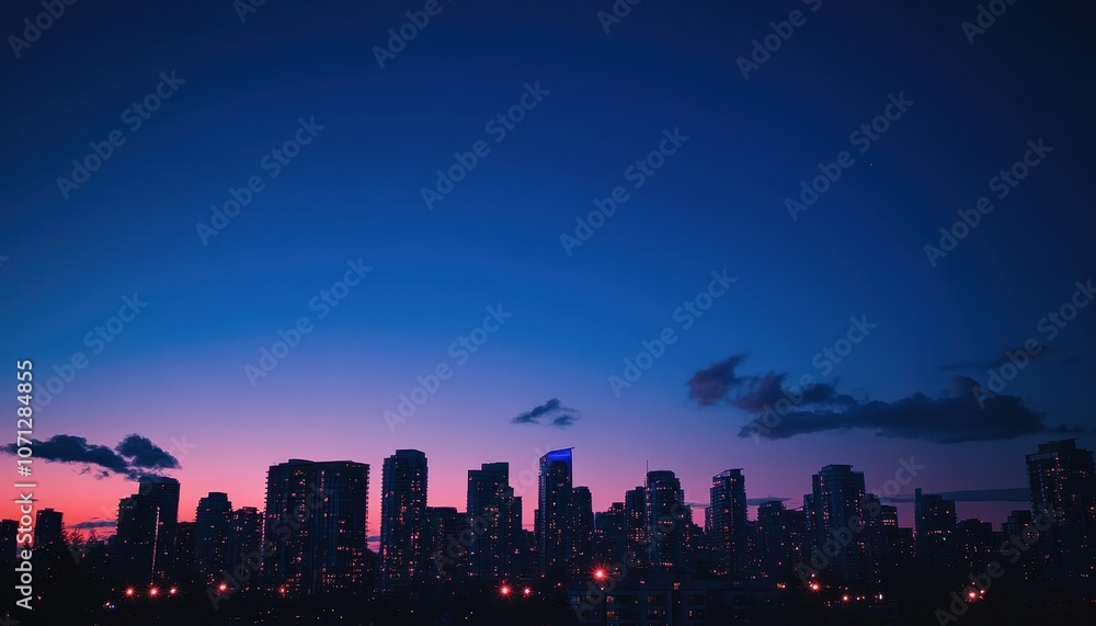 Fototapeta premium Silhouetted City Skyline at Twilight with a Pink and Blue Sky