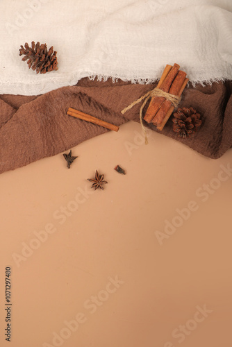 Rustic Background with Cinnamon Sticks, Pinecones, and Star Anise on Neutral Fabric photo