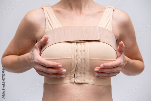 woman patient In post surgical Compression bra, implants stabilizer bra after plastic surgery medical mammoplasty, mastopexy breast enlargement, on white background