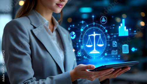 professional woman in suit holds tablet displaying digital scales of justice, symbolizing law and technology integration in modern legal practices