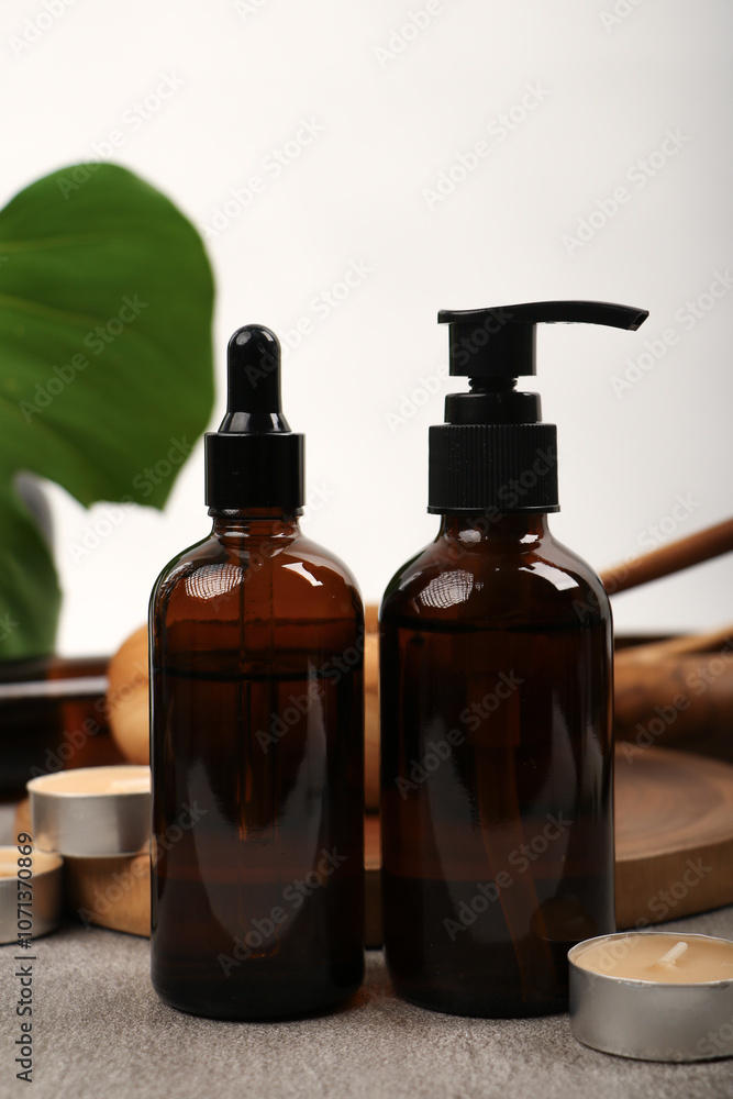 Amber Glass Bottles with Wooden Mortar and Tropical Leaves on Rustic Fabric Amber Glass Bottles with Wooden Mortar and Tropical Leaves on Rustic Fabric