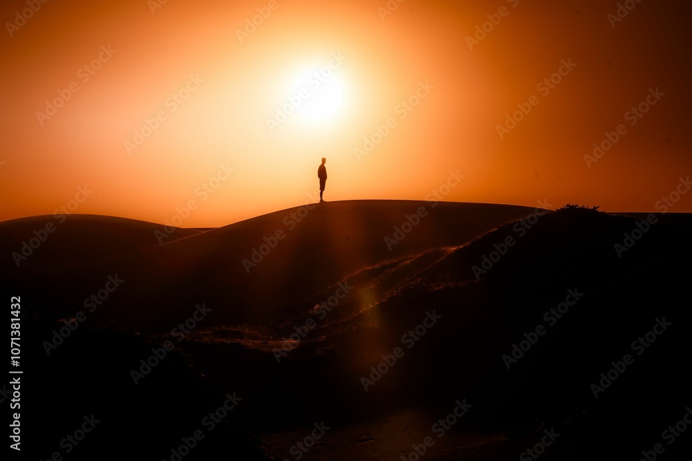 Silhouette scene of man standing on a dune against red dusk sky watching sunset in Valparaiso, Chile Silhouette scene of man standing on a dune against red dusk sky watching sunset in Valparaiso, Chile