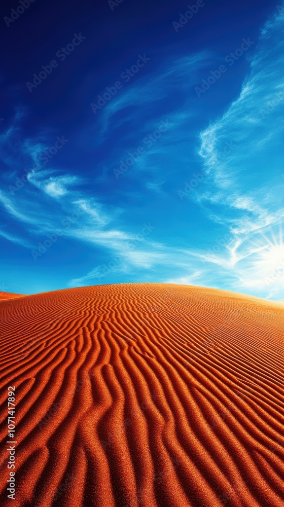 Naklejka premium A breathtaking view of undulating orange sand dunes beneath a vast blue sky, creating a serene and captivating natural landscape that invites tranquility and reflection.