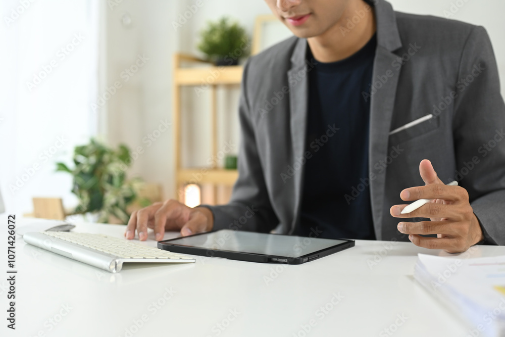 Fototapeta premium Young businessman using digital tablet at modern office