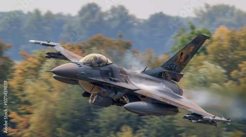 A military jet flying low over a colorful landscape, showcasing its agility and power. photo