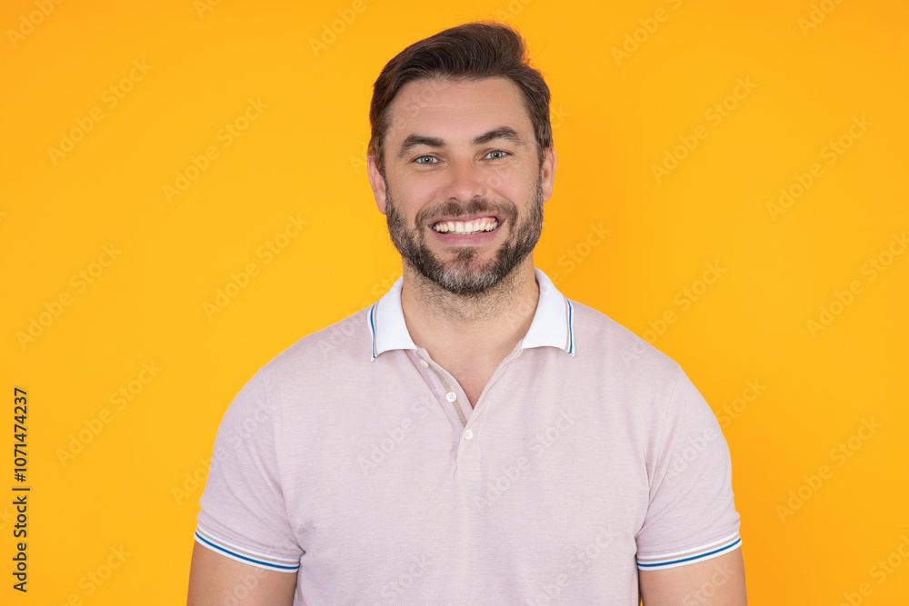Obraz premium Studio portrait of Smiling male model isolated on yellow. Positive man in good mood. Friendly and smiling man. Handsome man looking at the camera. Positive person. Portrait of laughing man.
