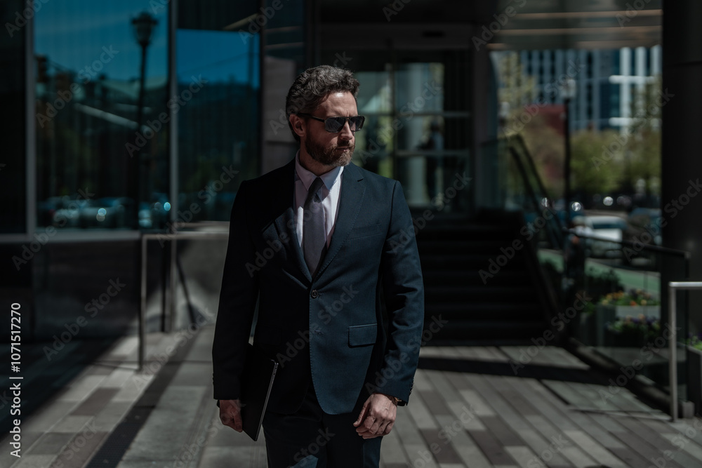 Confident business man standing outdoor on modern office building. Business success. Business man thinking outdoor. Modern businessman in full suit standing outdoors near office cityscape. Confident business man standing outdoor on modern office building. Business success. Business man thinking outdoor. Modern businessman in full suit standing outdoors near office cityscape.