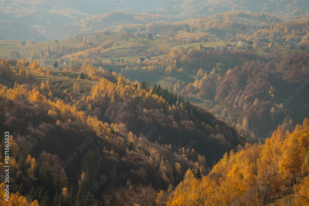 Fototapeta premium Scenic autumn overview of Magura village in Romania, near the Piatra Craiului mountains