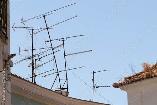 Multiple and messy analog terrestrial directional television antennas on a rooftop in Lisbon, Portugal photo