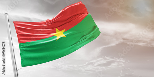 Burkina Faso national flag cloth fabric waving on beautiful grey Background.