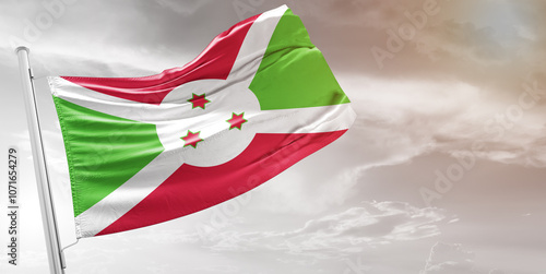 Burundi national flag cloth fabric waving on beautiful grey Background.