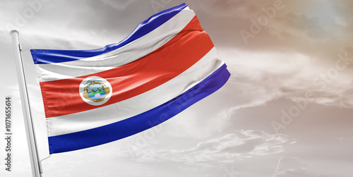 Costa Rica national flag cloth fabric waving on beautiful grey Background.