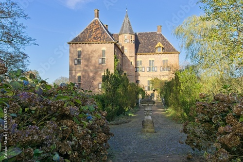 Vorden Castle in the fall, with a tiled path lined with almost blooming hydrangeas. 