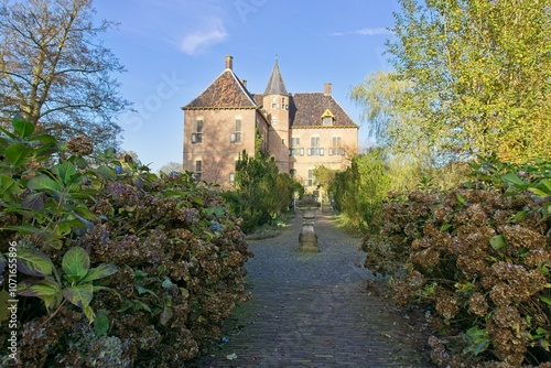 Vorden Castle in the fall, with a tiled path lined with almost blooming hydrangeas.   photo