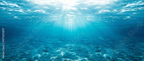 A serene underwater view of the clear, turquoise ocean with sunlight filtering through the water's surface.