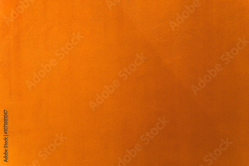 Oriole or orange paint on cement wall texture as background.