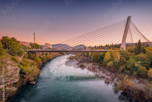 Millennium Bridge in Podgorica at sunset, spanning the Moraca River, offering a stunning view of the cityscape and a perfect urban landmark for travelers.