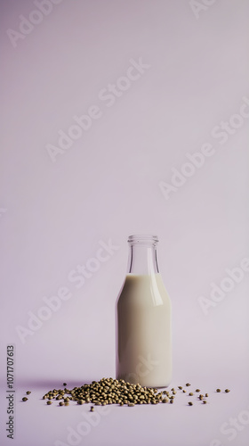 A glass bottle of hemp milk stands elegantly against a soft lavender background with scattered hemp seeds at its base photo