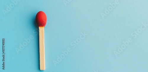 Minimalist red matchstick on blue background