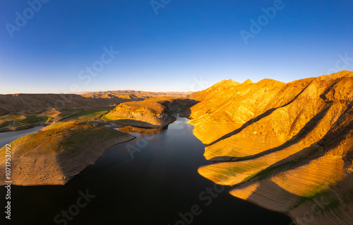 Panoramic aerial view on picturesque Azat reservoir and Eranos mountain at bright sunny evning sunset. Lake with blue water in arid area and Yeranos mountains range. Beautiful landscape. Armenia. photo