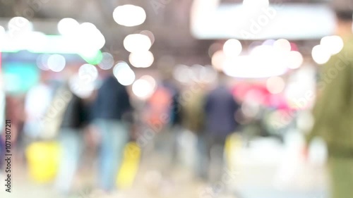 Intentionally blurred footage of people visiting pavilions and booths during a business trade fair 