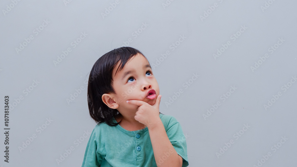 portrait of asian beautiful little girl holding chin, thinking concept with light color background. portrait of asian beautiful little girl holding chin, thinking concept with light color background.