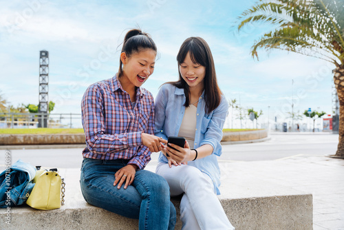 Happy beautiful chinese women friends bonding outdoors in the city - Playful pretty asian female adults meeting and having fun outside, concepts about lifestyle and friendship