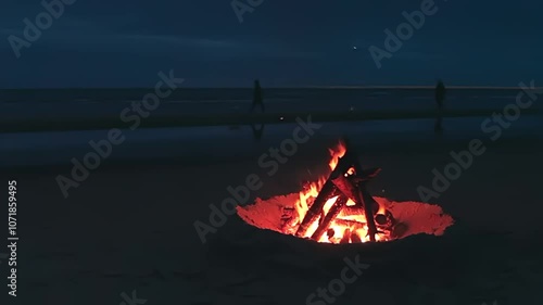 Bonfire on the Beach against a Wavy Sea or Ocean at Night in a Cloudy Time. Burning Campfire on Sand. Wood on Fire. Place for Bonfire. Fire Pit on Seaside. Signal Fire - Static Shot
