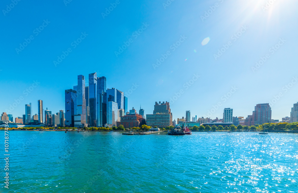 Naklejka premium Manhattan skyscrapers seen from the water under a shining sun