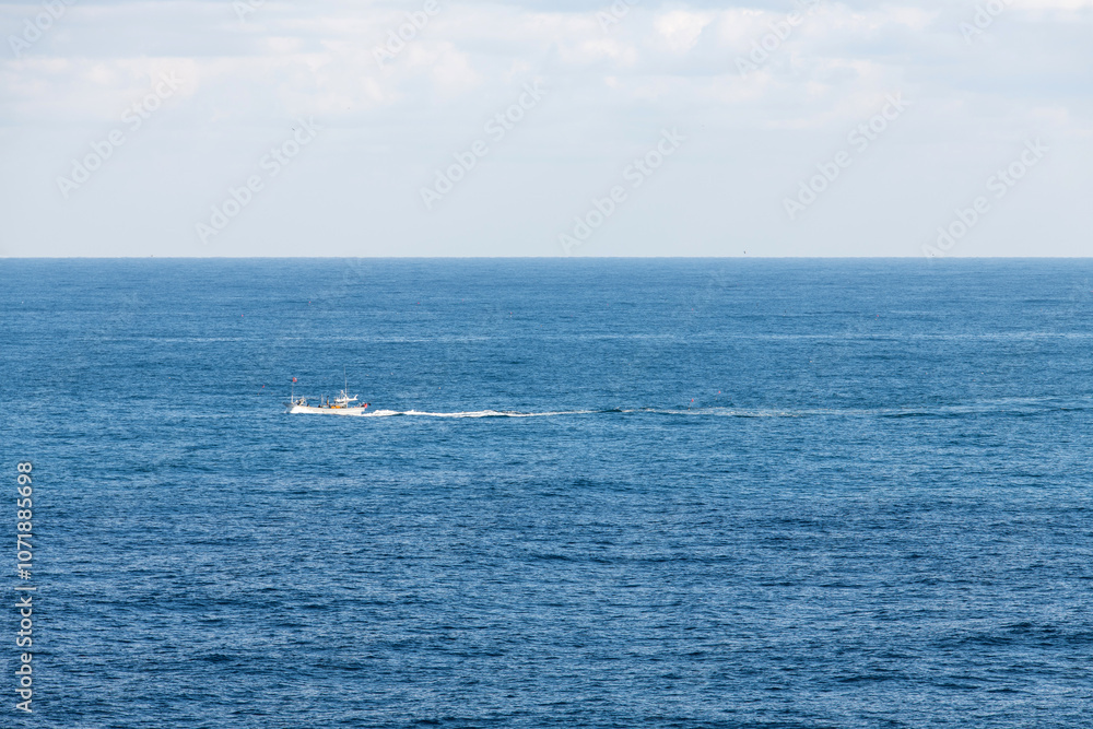 fishing boat on the sea with big white clouds fishing boat on the sea with big white clouds