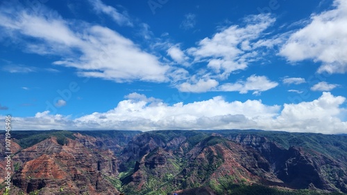 Waimea canyon - cloudy and clear skies, landscape view, long horizon, red lava rocks, green foliage. Version 2 photo