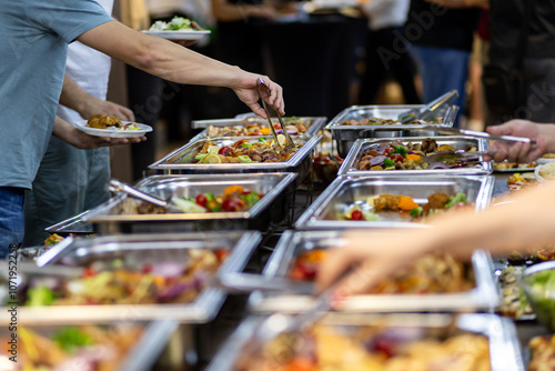 Fotografía Buffet spread featuring a variety of dishes, with guests serving themselves at a