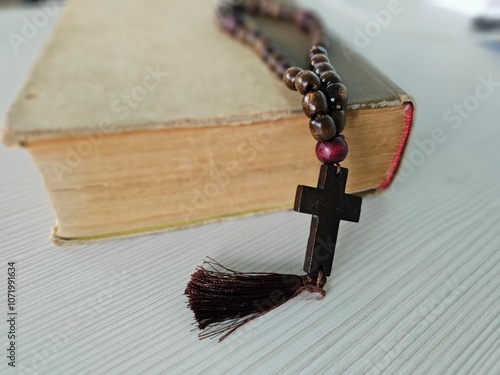 Wooden rosary beads lying on a closed bible christianity photo