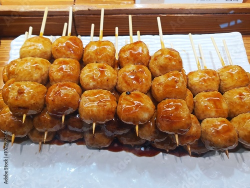 Japan Mitarashi-dango. Mitarashi-dango are traditional Japanese rice flour dumplings that are skewered onto sticks in groups of 3–5 and are covered with a sweet soy sauce glaze photo