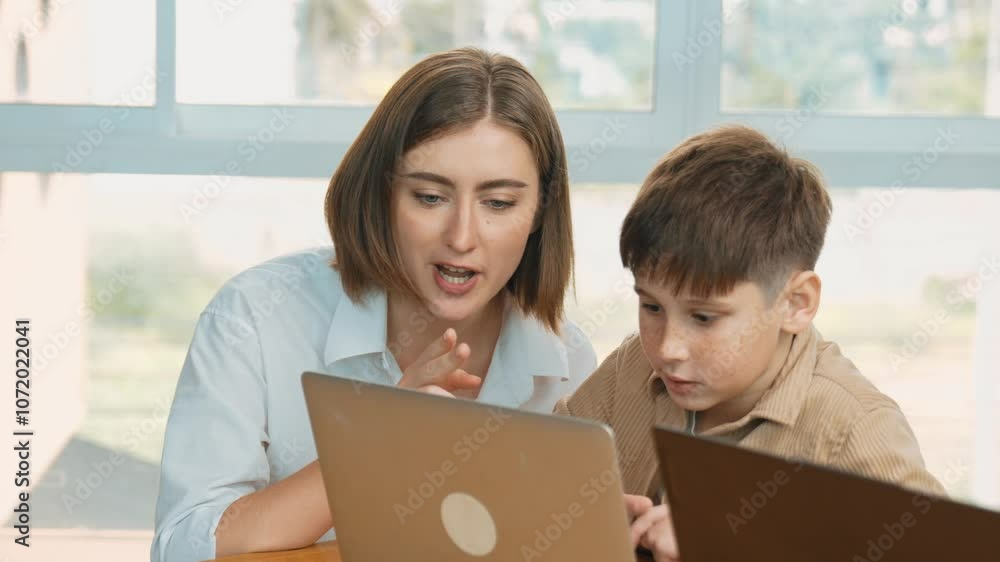 Smart boy playing laptop with multicultural friend learning prompt at STEM technology class. Caucasian student study about programing system while teacher looking at screen checking code. Erudition. Smart boy playing laptop with multicultural friend learning prompt at STEM technology class. Caucasian student study about programing system while teacher looking at screen checking code. Erudition.