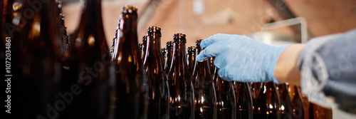 Φωτογραφία Header image of production workers hand in protective glove reaching to take gla