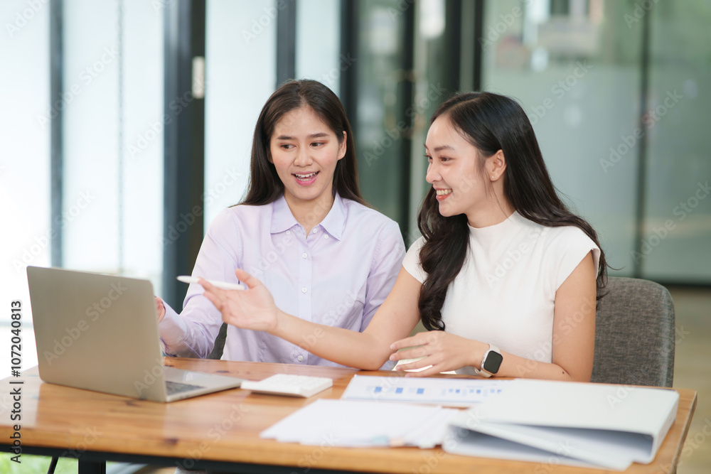 Businessman, two Asian women give advice, discuss work, documents on laptop at office Businessman, two Asian women give advice, discuss work, documents on laptop at office