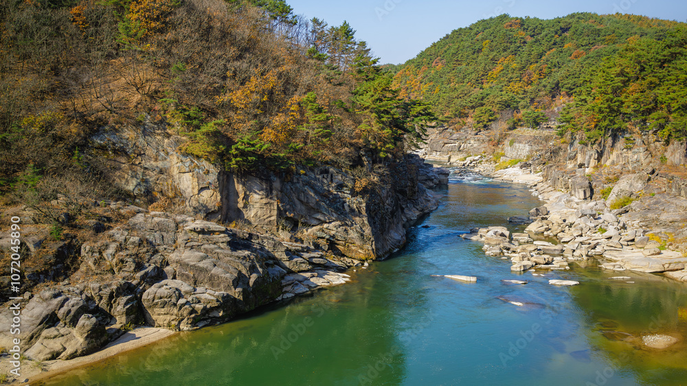 Autumn scenery of the Hantan River Columnar Joint Road, with canyons and cliffs formed by the river flowing through the volcanic terrain. (emerald water, blue sky and colorful leaves) Autumn scenery of the Hantan River Columnar Joint Road, with canyons and cliffs formed by the river flowing through the volcanic terrain. (emerald water, blue sky and colorful leaves)