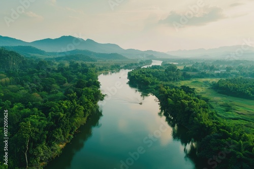 A serene scene of a river flowing peacefully through a dense and vibrant green forest