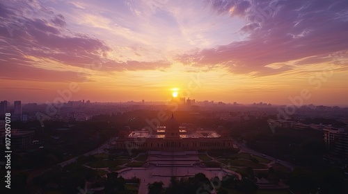 A majestic building silhouetted against a vibrant sunset over the cityscape.