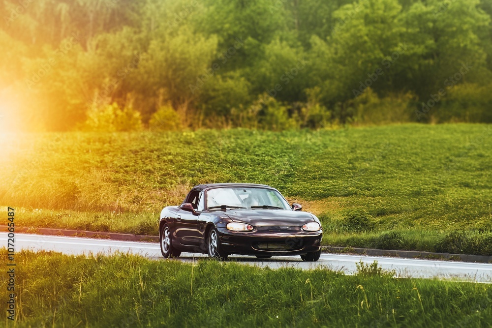 Classic Japanese roadster cruising scenic country road at sunset Classic Japanese roadster cruising scenic country road at sunset