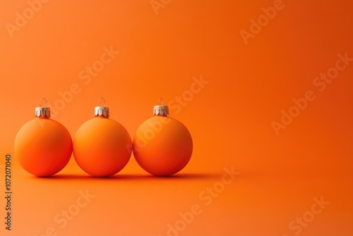 Three orange Christmas ornaments on an orange background