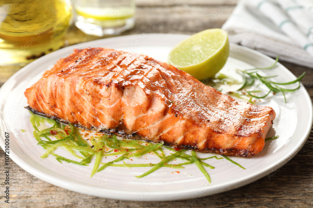 Delicious grilled salmon fillet served on wooden table, closeup Delicious grilled salmon fillet served on wooden table, closeup