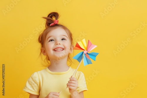 A young girl is holding a colorful paper fan and smiling