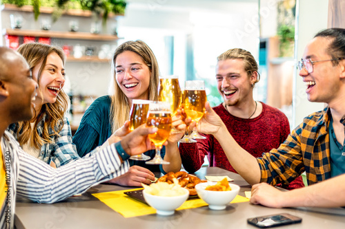 Happy friends drinking beer at brewery bar restaurant on weekend - Friendship concept with young smiling people having fun together toasting brew pint on happy hour at pub - Men and women at home