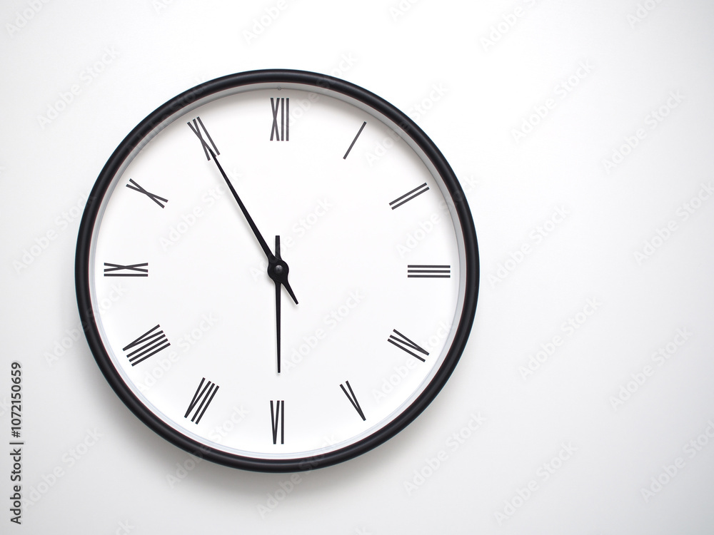 Clock Showing 17.55/05.55 with Roman Numerals – Simple Round Clock for Concepts of Time Management and Scheduling. Clock Showing 17.55/05.55 with Roman Numerals – Simple Round Clock for Concepts of Time Management and Scheduling.