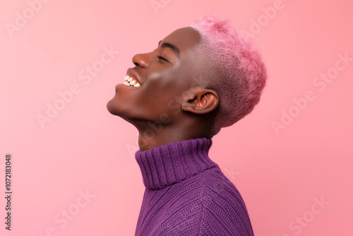 queer black man with short pink hair in  a purple sweater smiling,  side profile on pink studio background