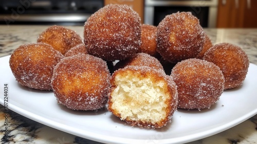 A plate of freshly baked, sugared donuts.